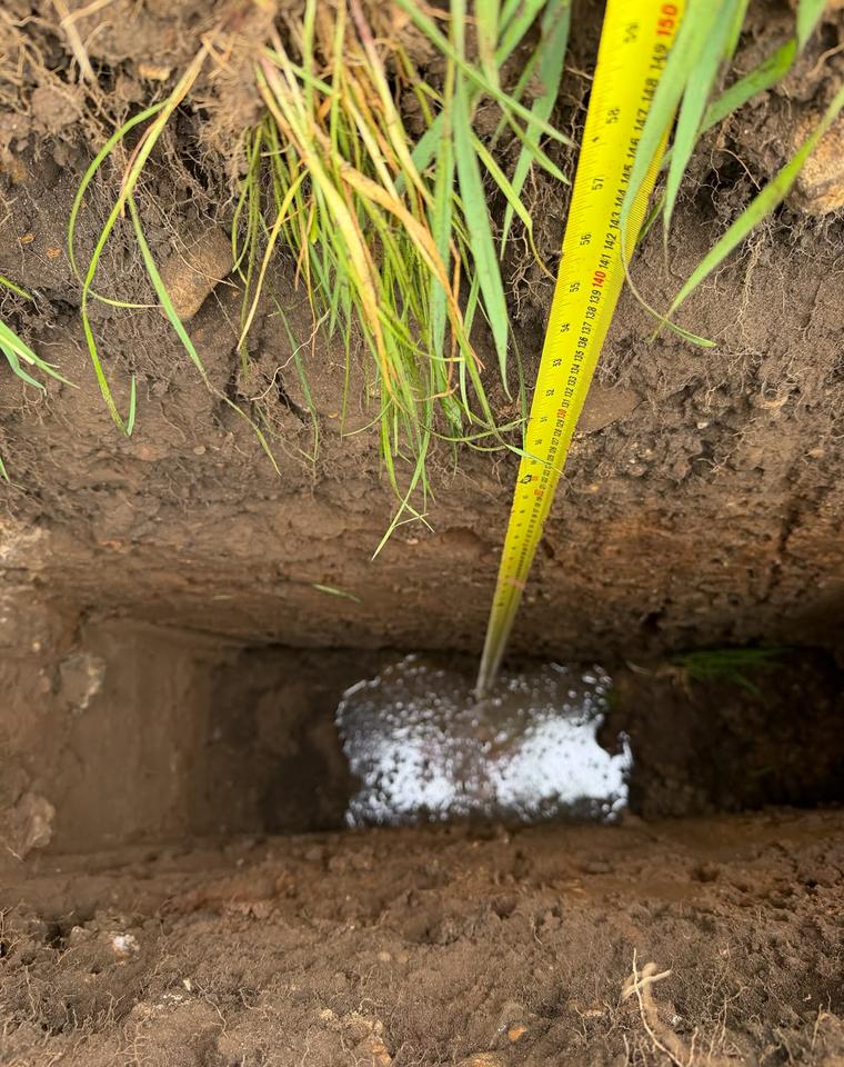 Percolation test pit with water draining into the ground